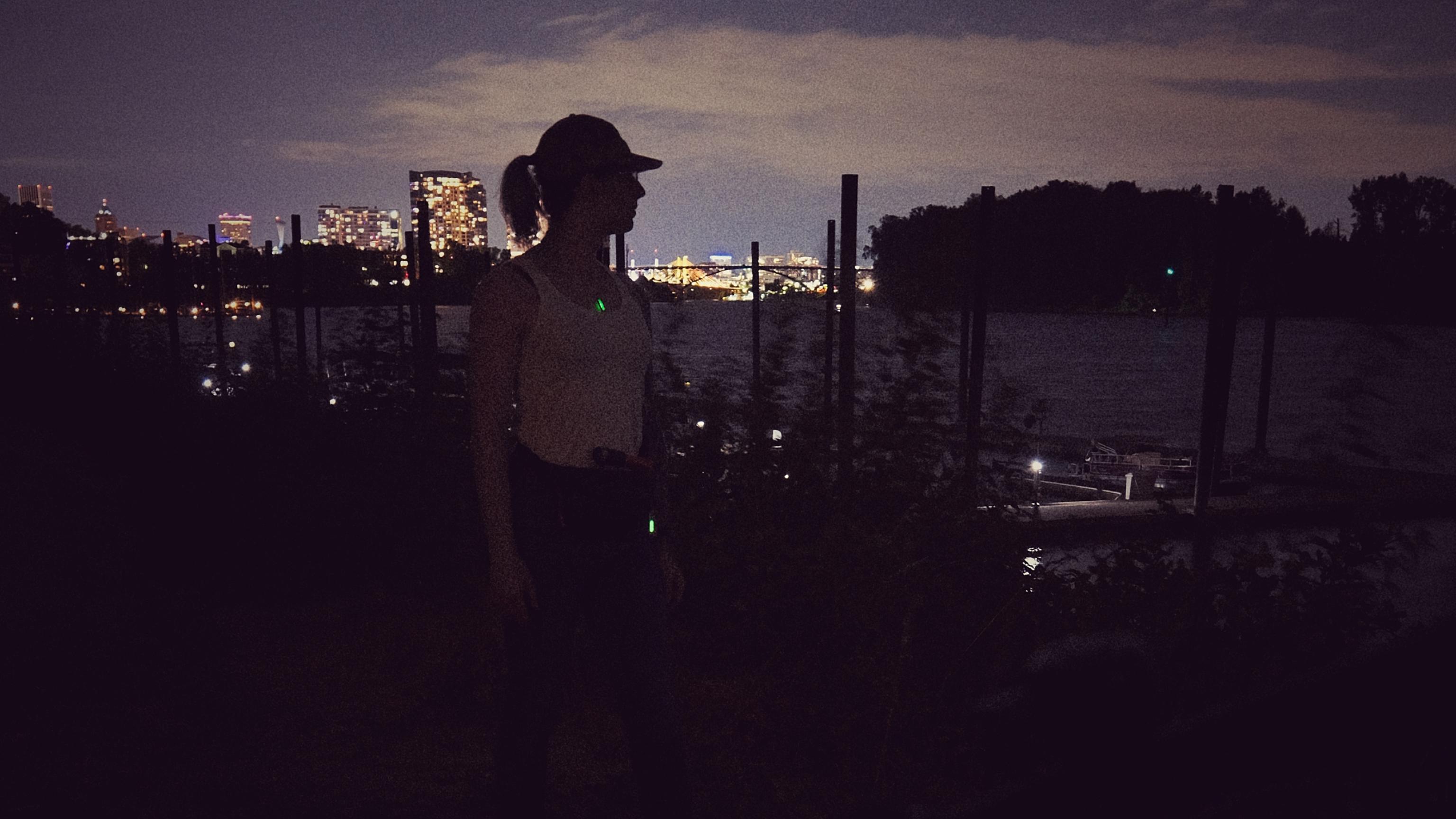 raven facing the Willamette River at night after riding her bike around town