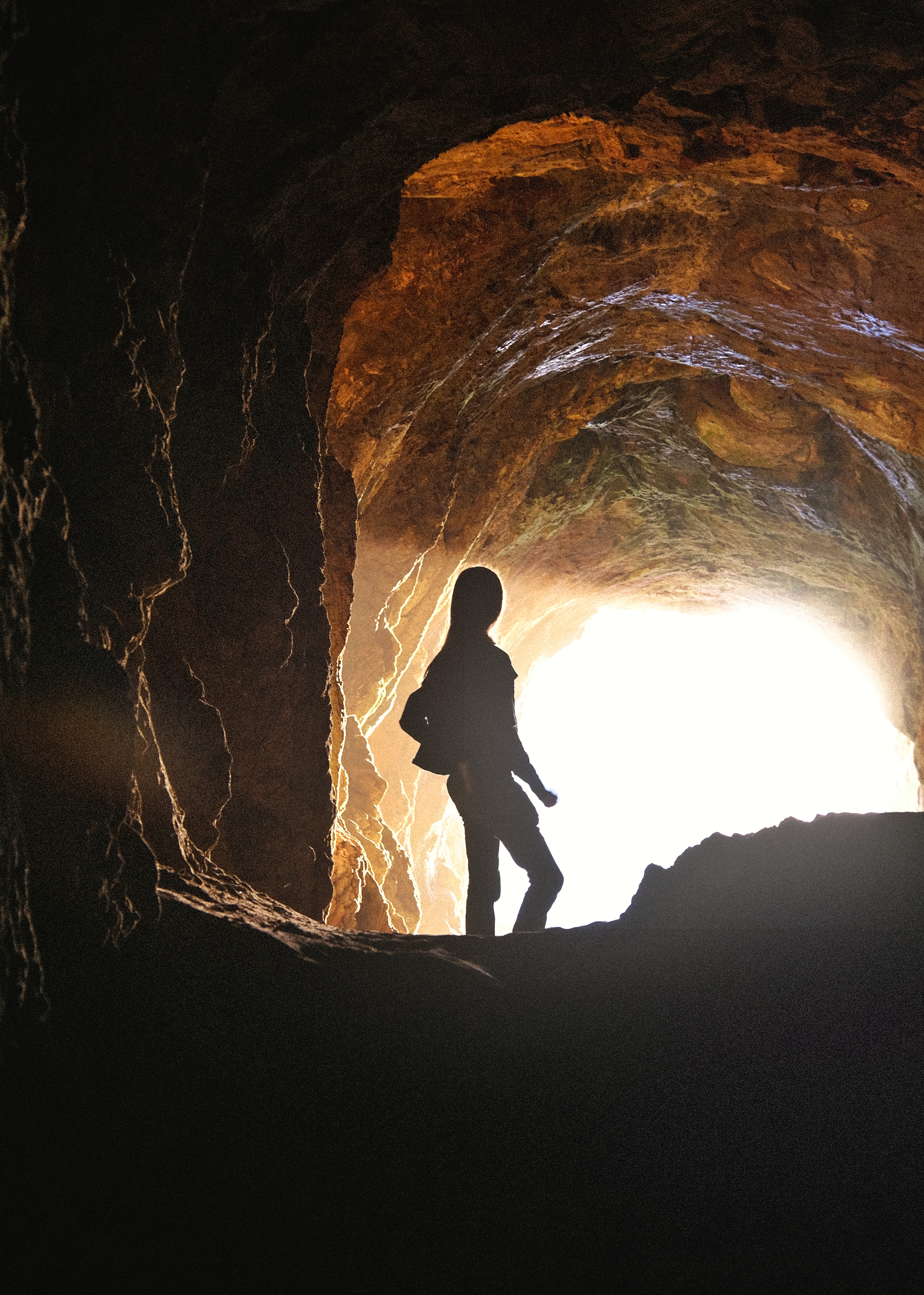 a woman in a cave with golden light