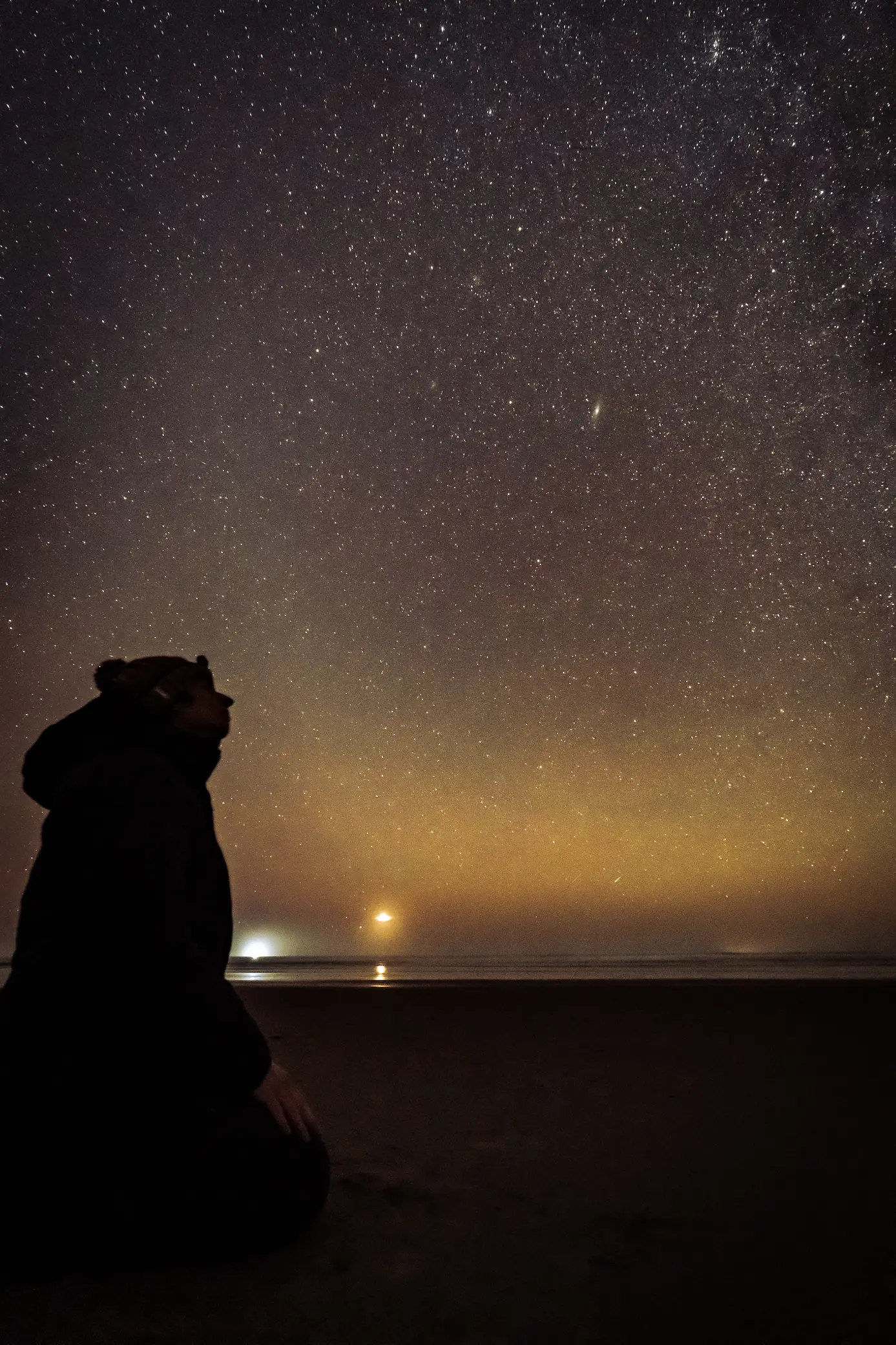 Person sitting on the ground looking at the stars