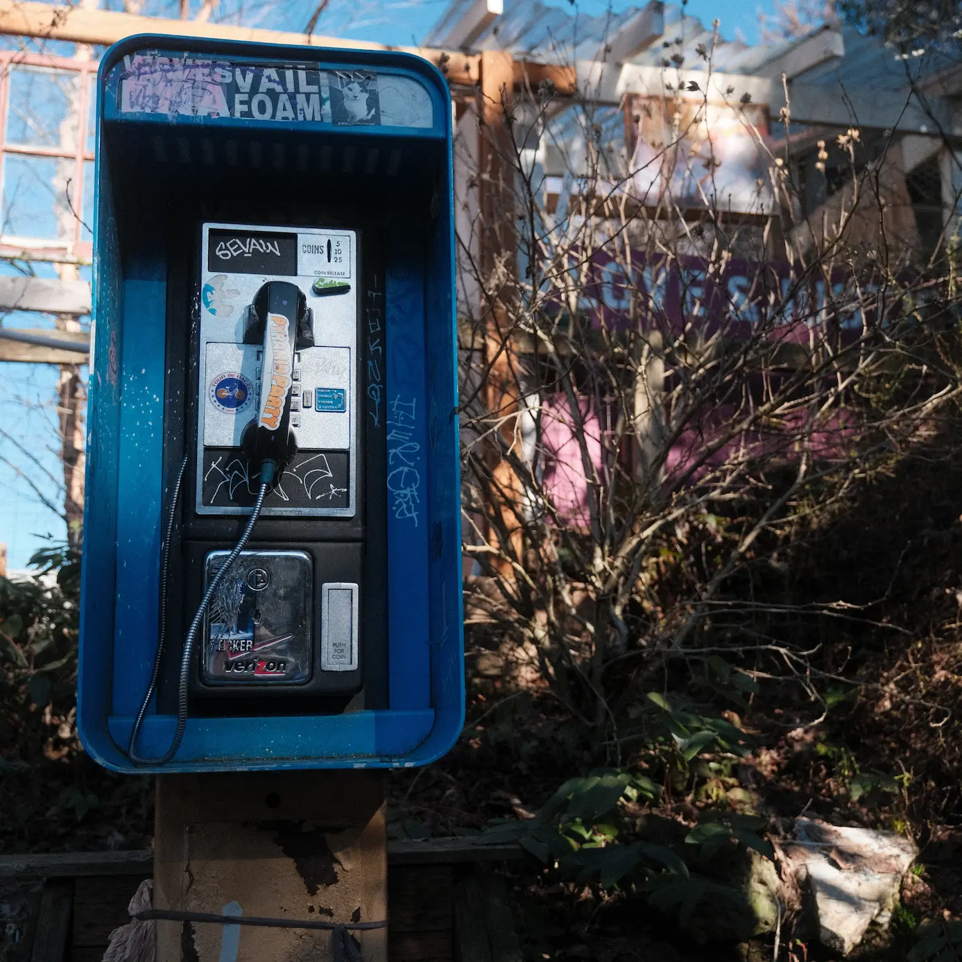 Photo of a payphone with a blue encasing and black handpiece