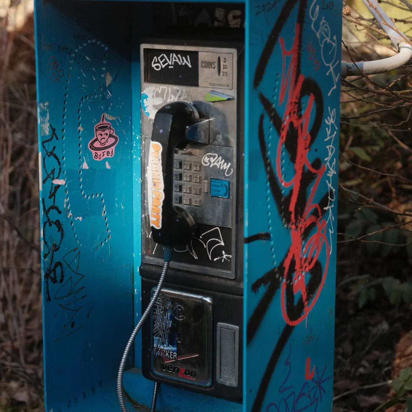 Photo of a payphone with a blue encasing and black handpiece