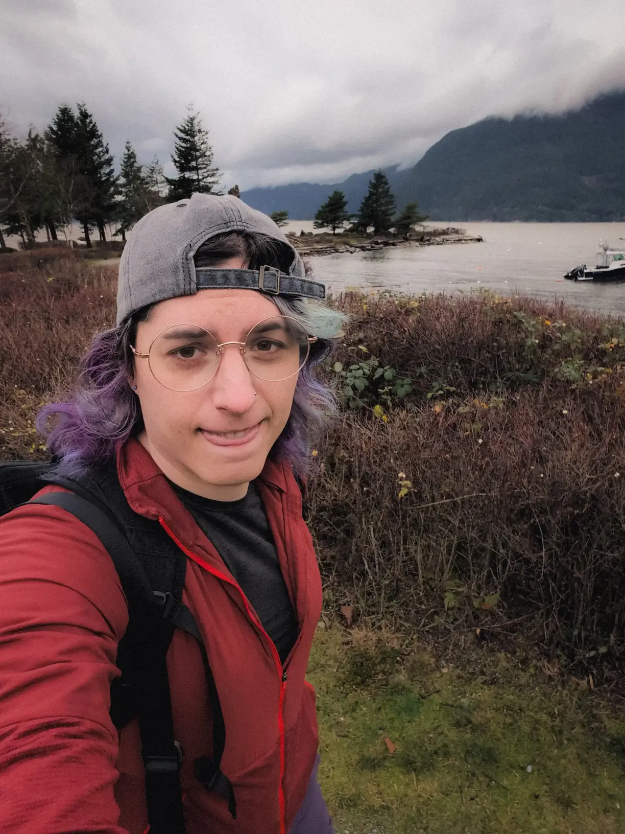 the author standing in front of Howe sound wearing her hat backwards making a cute tongue sticking out face