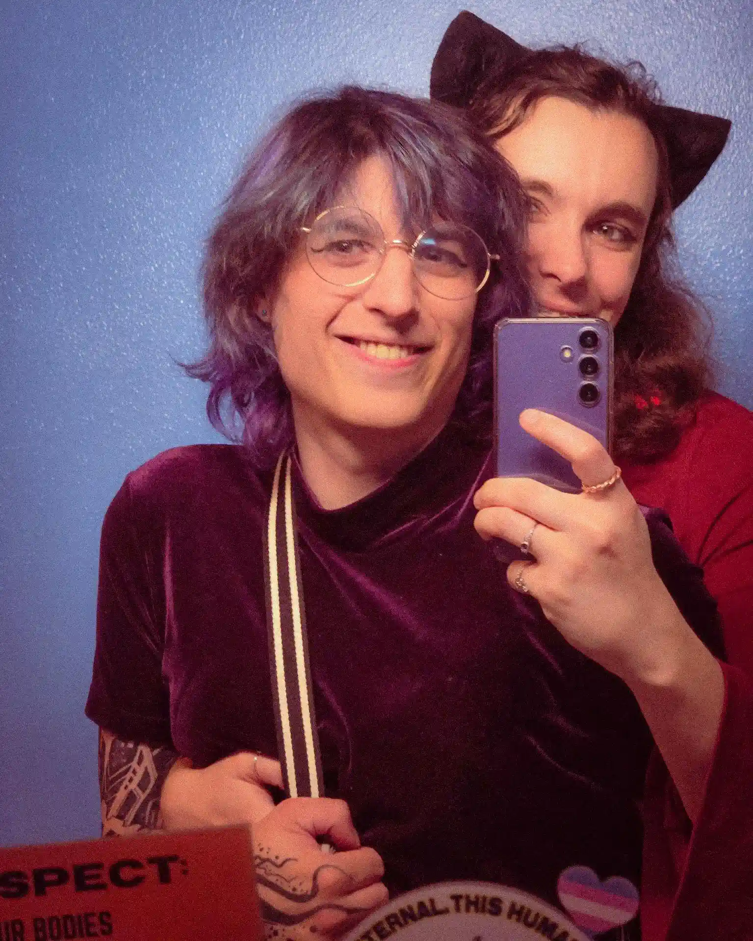 author looking at the camera holding a peace sign, smiling, with mountains behind her
